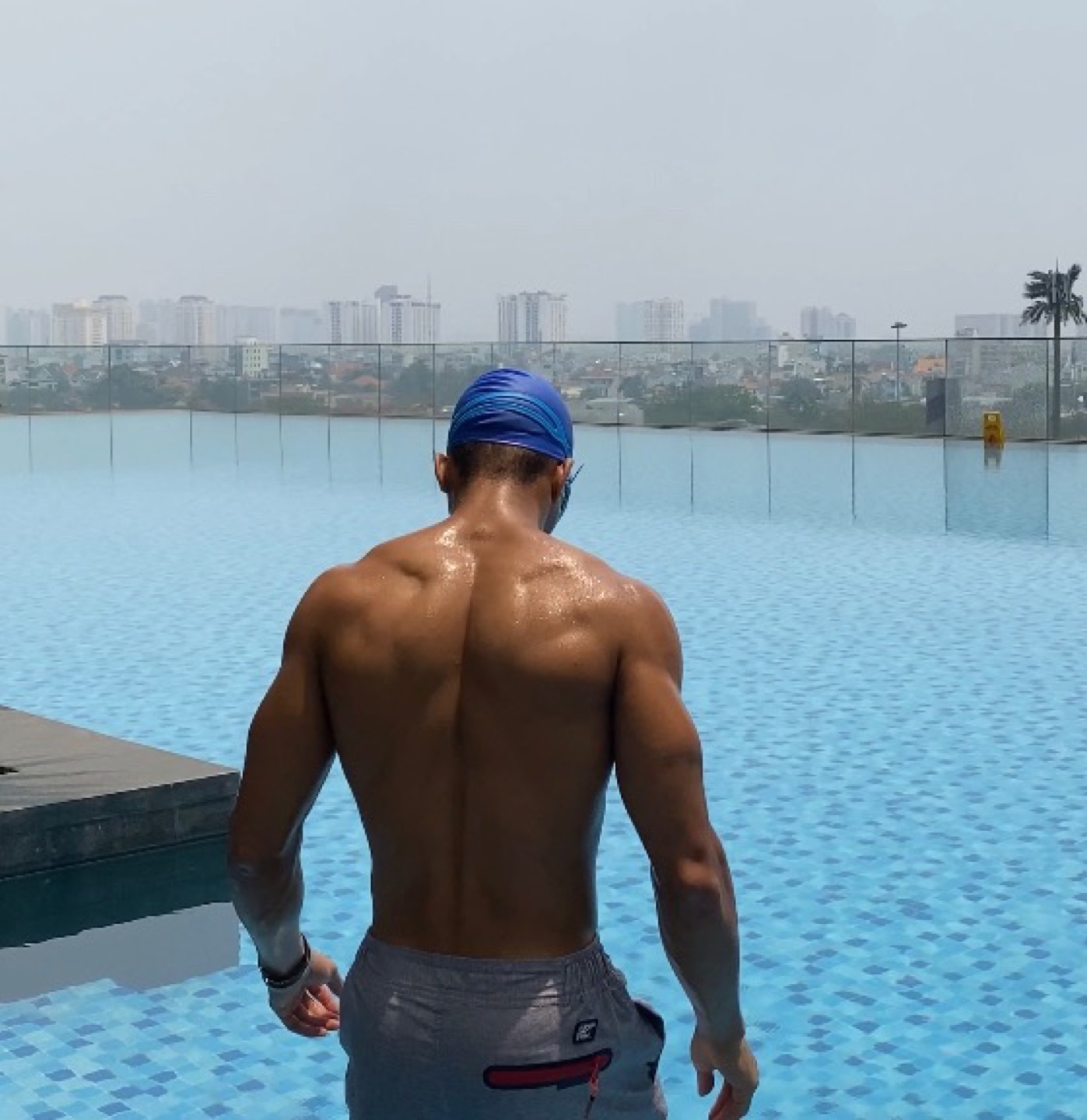 Oyotta seen from behind at the edge of a rooftop pool
